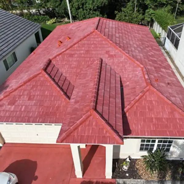 inf-10 - Infinity Roofing - A Stronghouse Partner Aerial view of a single-story house with a red tiled roof and several rectangular solar panels mounted on the roof.